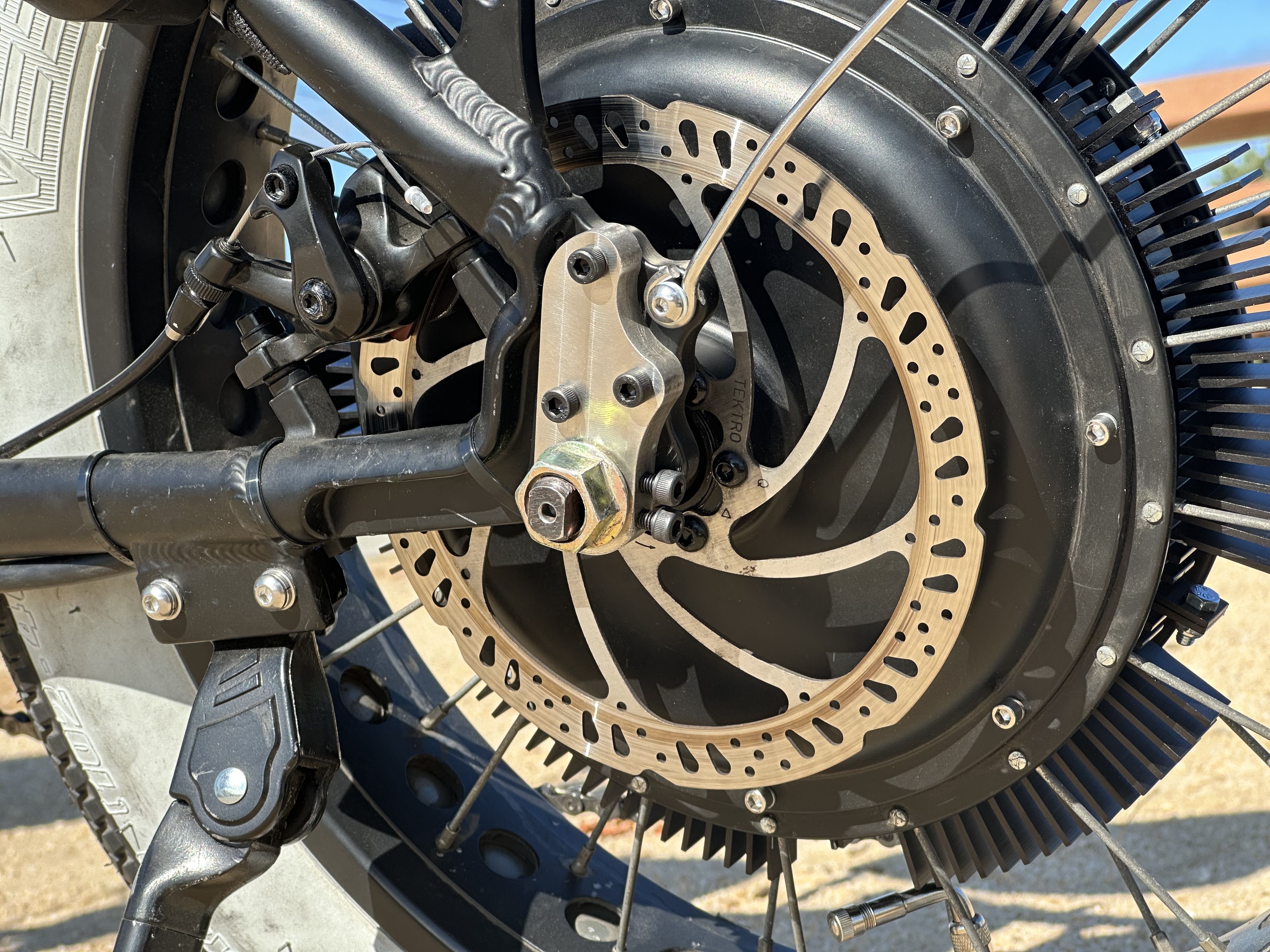 Closeup of the bikes rear tire, left side, focused on the torque arm